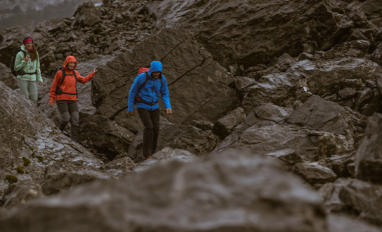 Randonneurs en montagne sous la pluie avec des imperméables